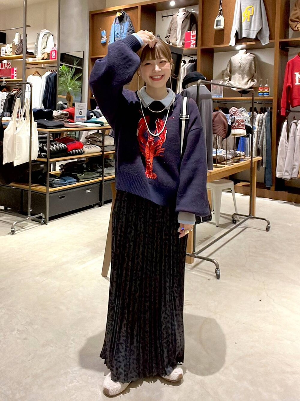 グレー系のスカート、ブラック系のショルダーバッグ、ベージュ系のスニーカーを着用したレディースの冬コーディネートの1枚目の写真