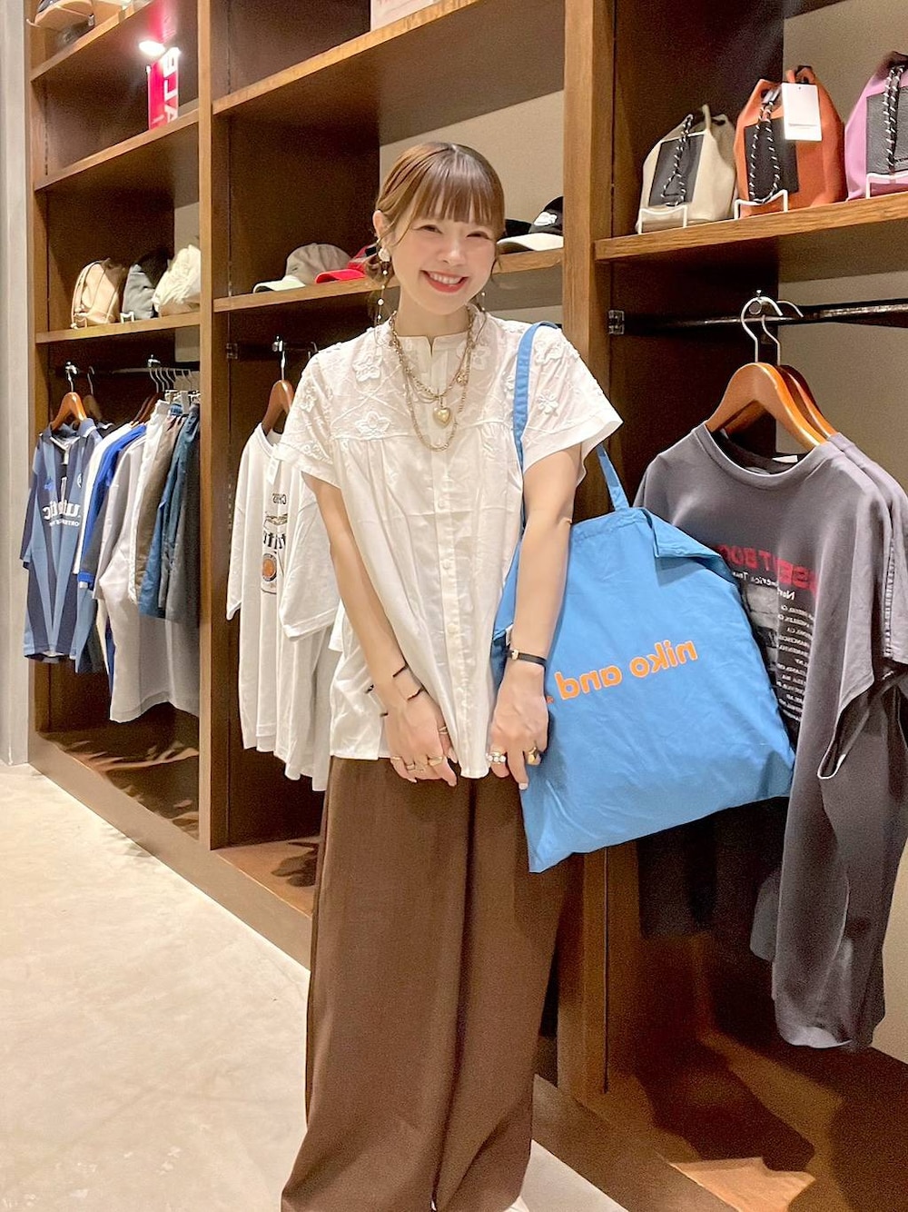 ブルー系のトートバッグ、ホワイト系のシャツ/ブラウス、ブラウン系のその他パンツを着用したレディースの夏コーディネートの1枚目の写真