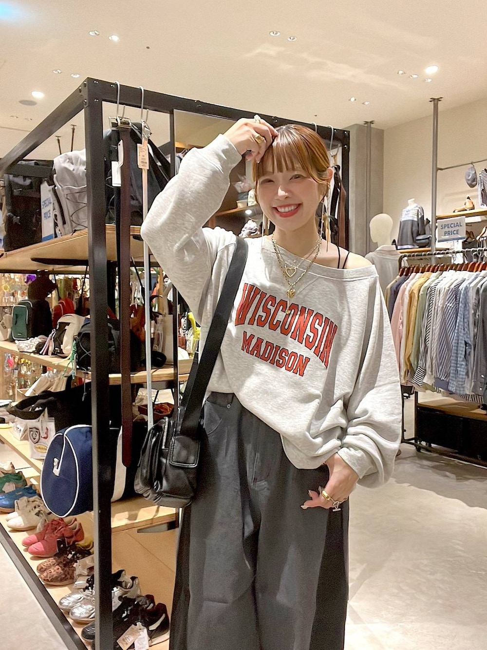 ベージュ系のスウェット、ブラック系のショルダーバッグ、イエロー系のネックレスを着用したレディースの秋コーディネートの1枚目の写真