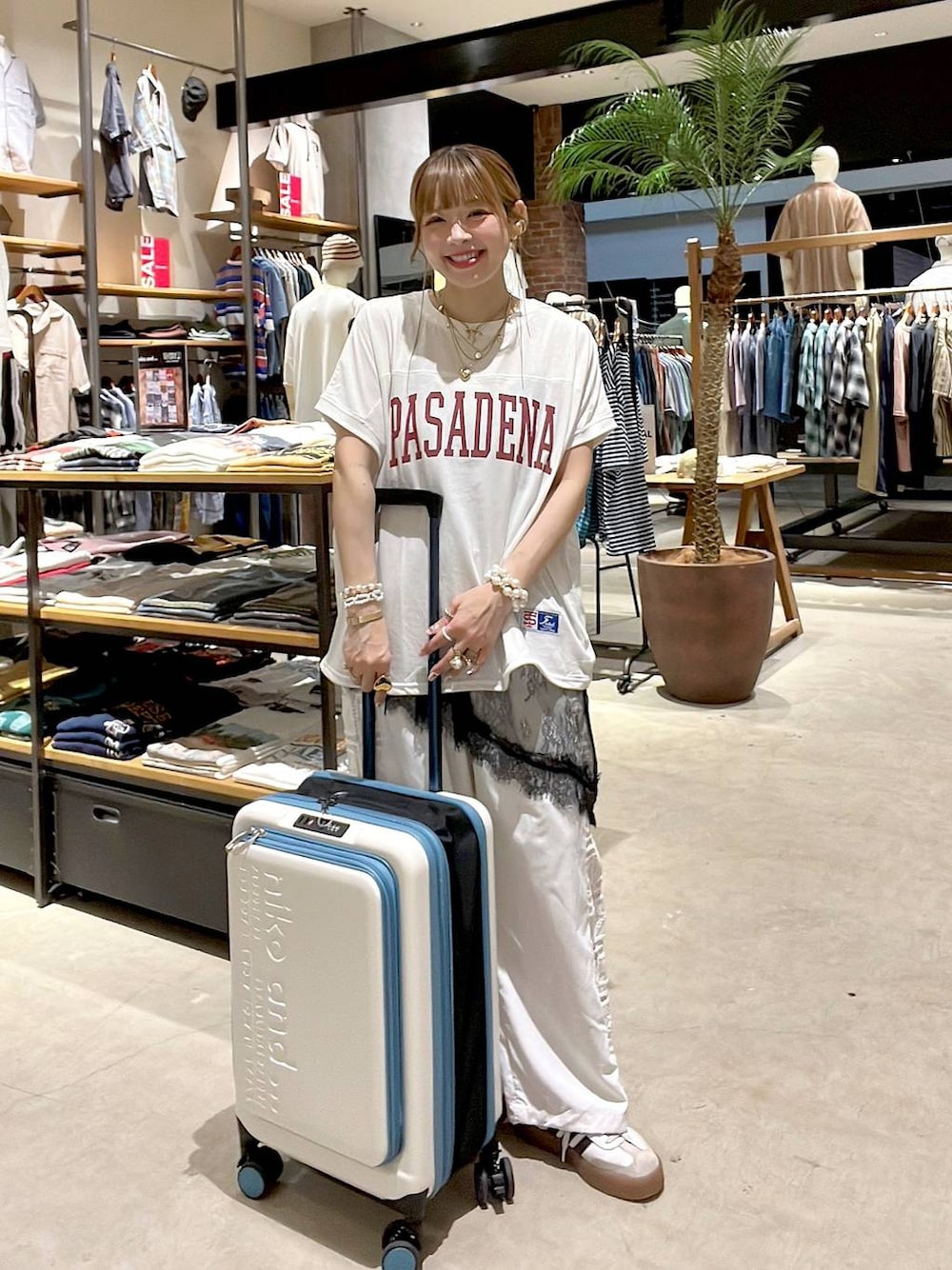 ホワイト系のその他パンツ、ベージュ系のスーツケース/キャリーバッグ、ホワイト系のバックパック/リュックを着用したレディースの夏コーディネートの1枚目の写真