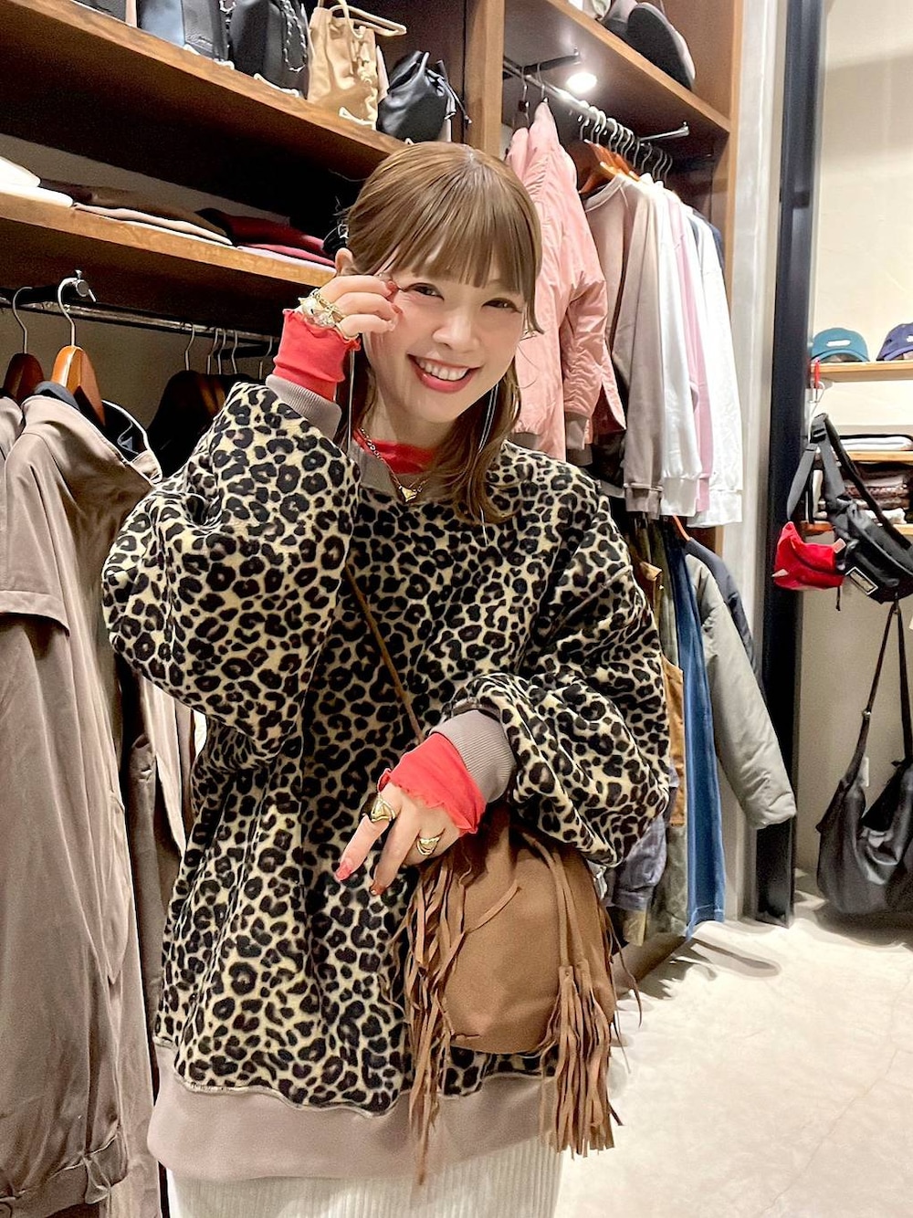 レッド系のTシャツ/カットソー、グレー系のスカート、ベージュ系のスニーカーを着用したレディースの冬コーディネートの1枚目の写真