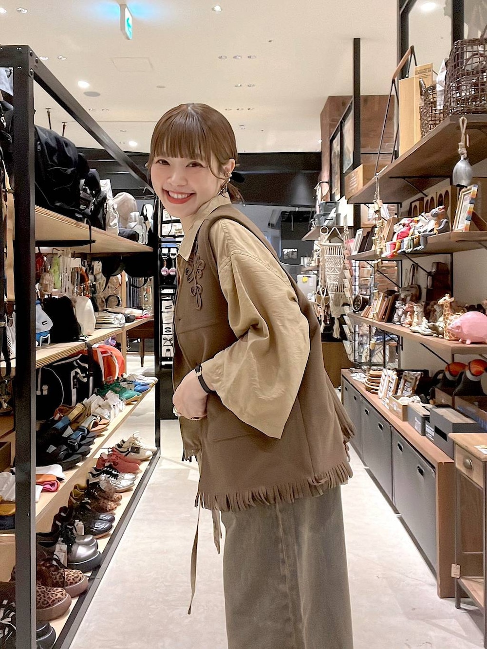 ベージュ系のシャツ/ブラウス、ブラウン系のデニムパンツ、イエロー系のベストを着用したレディースの夏コーディネートの1枚目の写真