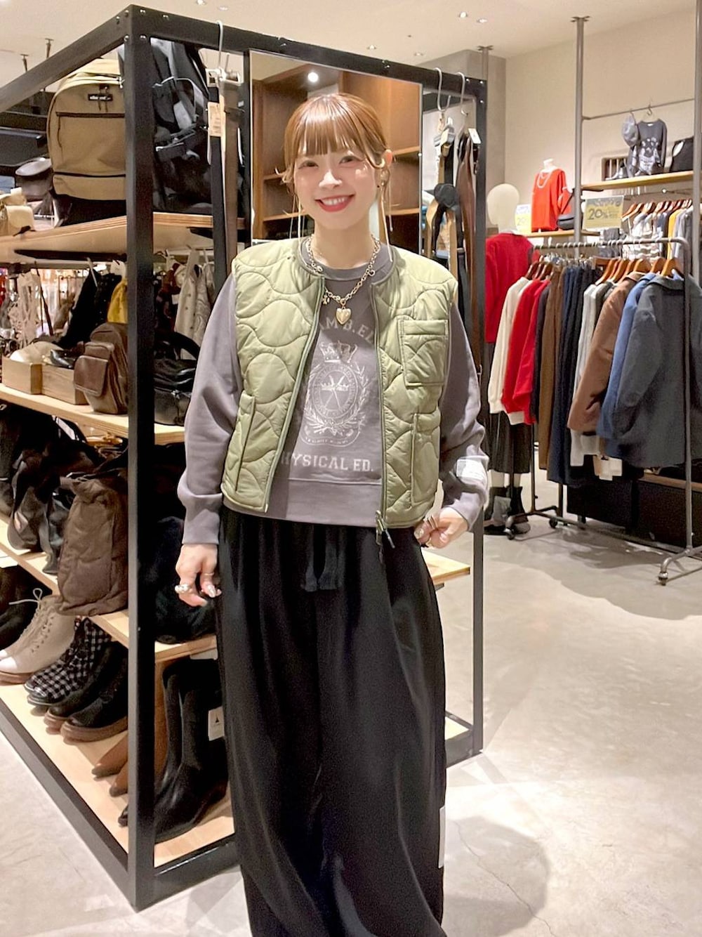 グリーン系のベスト、グレー系のTシャツ/カットソーを着用したレディースの秋コーディネートの1枚目の写真