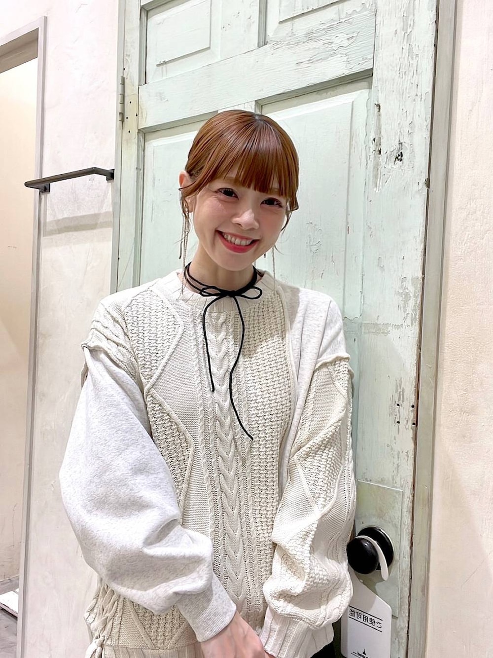 その他のショルダーバッグ、ベージュ系のニット/セーター、グリーン系のスカートを着用したレディースの冬コーディネートの1枚目の写真