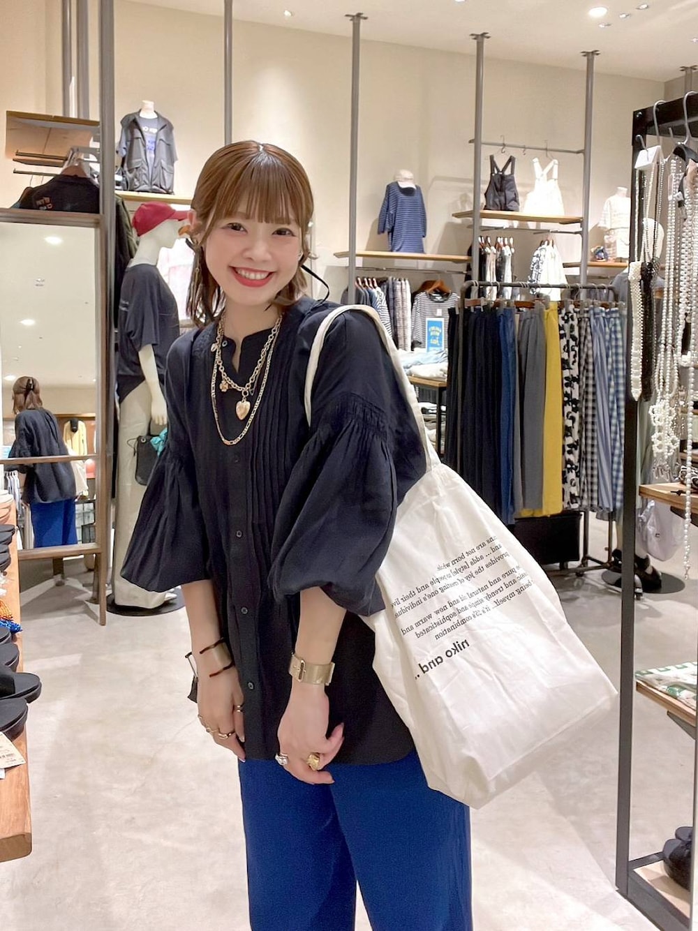 ベージュ系のトートバッグ、ブラック系のシャツ/ブラウス、ブルー系のその他パンツを着用したレディースの春コーディネートの1枚目の写真