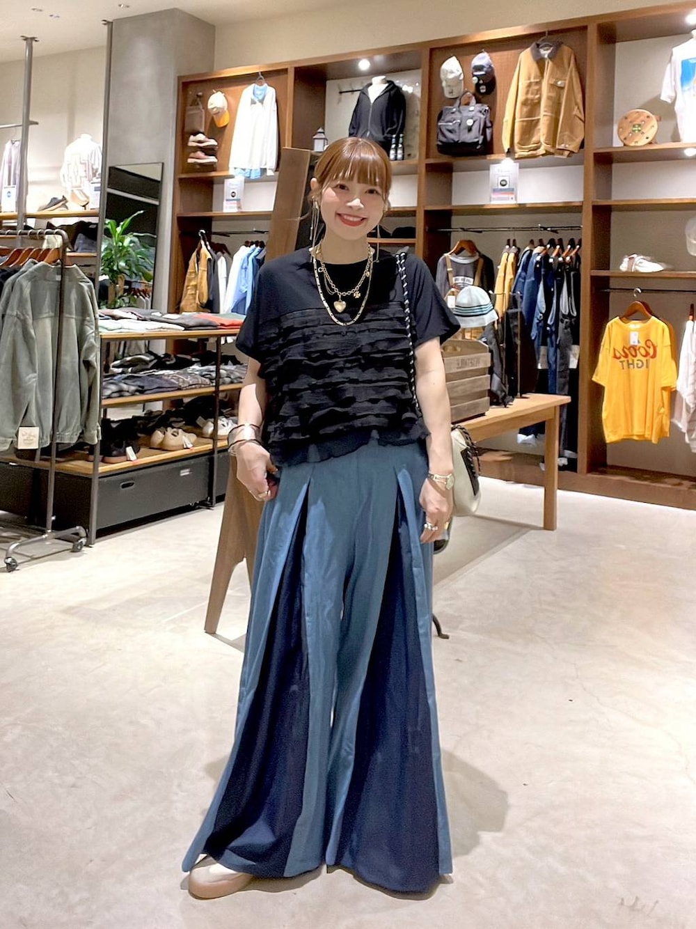 グレー系のショルダーバッグ、ブラック系のTシャツ/カットソー、ゴールド系のネックレスを着用したレディースの秋コーディネートの1枚目の写真