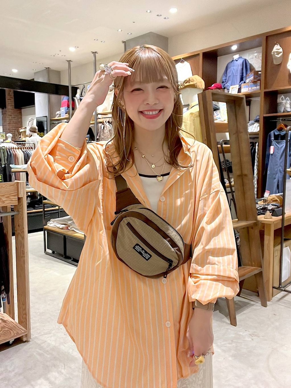 ベージュ系のスニーカー、ベージュ系のボディバッグ/ウエストポーチ、ベージュ系のキャミソールを着用したレディースの春コーディネートの1枚目の写真