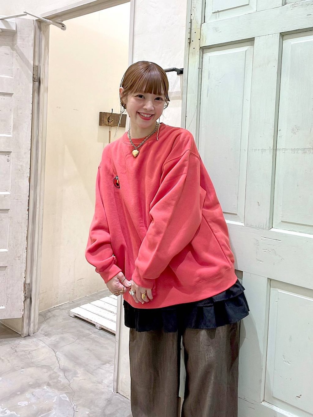 ブラウン系のその他パンツ、ブラック系のパンプス、レッド系のスウェットを着用したレディースの冬コーディネートの1枚目の写真