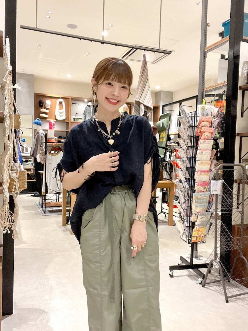 ブラック系のシャツ/ブラウス、グリーン系のその他パンツ、ゴールド系のネックレスを着用したレディースの夏コーディネートの1枚目の写真