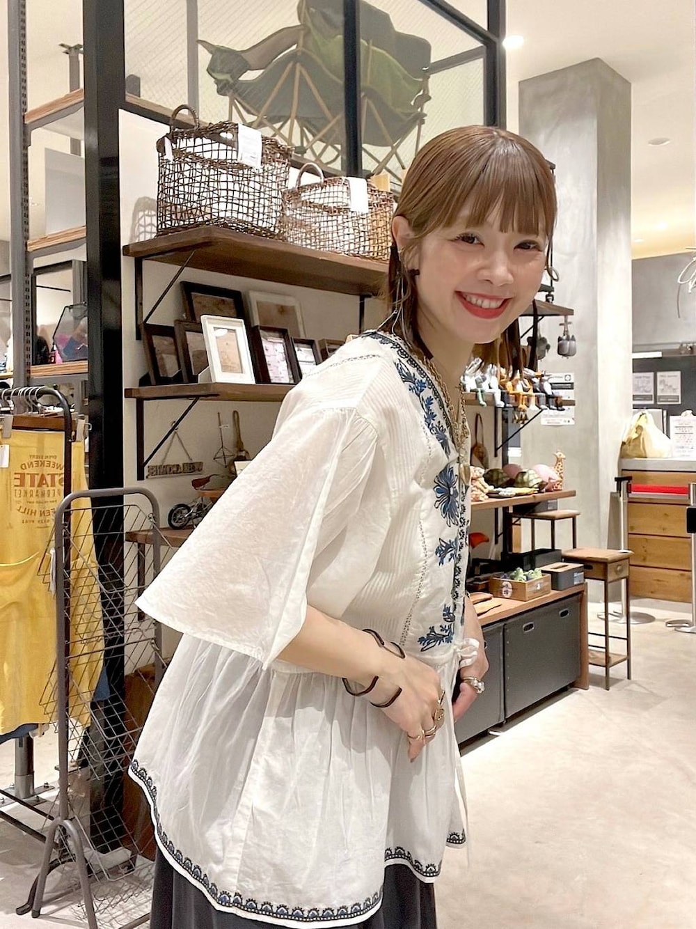 グレー系のスカート、ホワイト系のシャツ/ブラウス、ブラック系のトートバッグを着用したレディースの春コーディネートの1枚目の写真