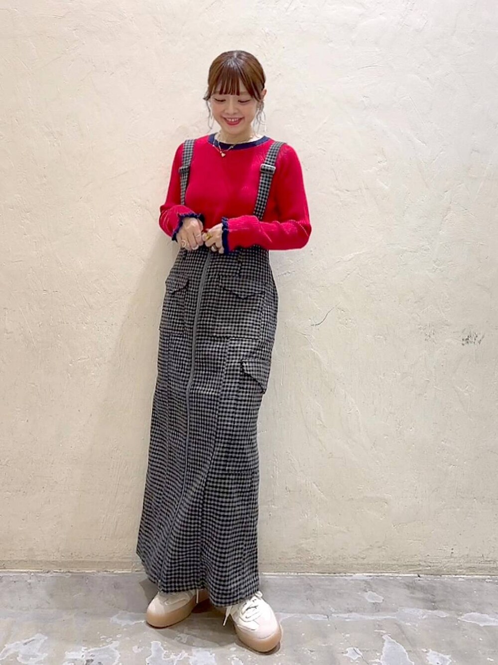 ブラック系のスカート、レッド系のニット/セーターを着用したレディースの秋コーディネートの1枚目の写真