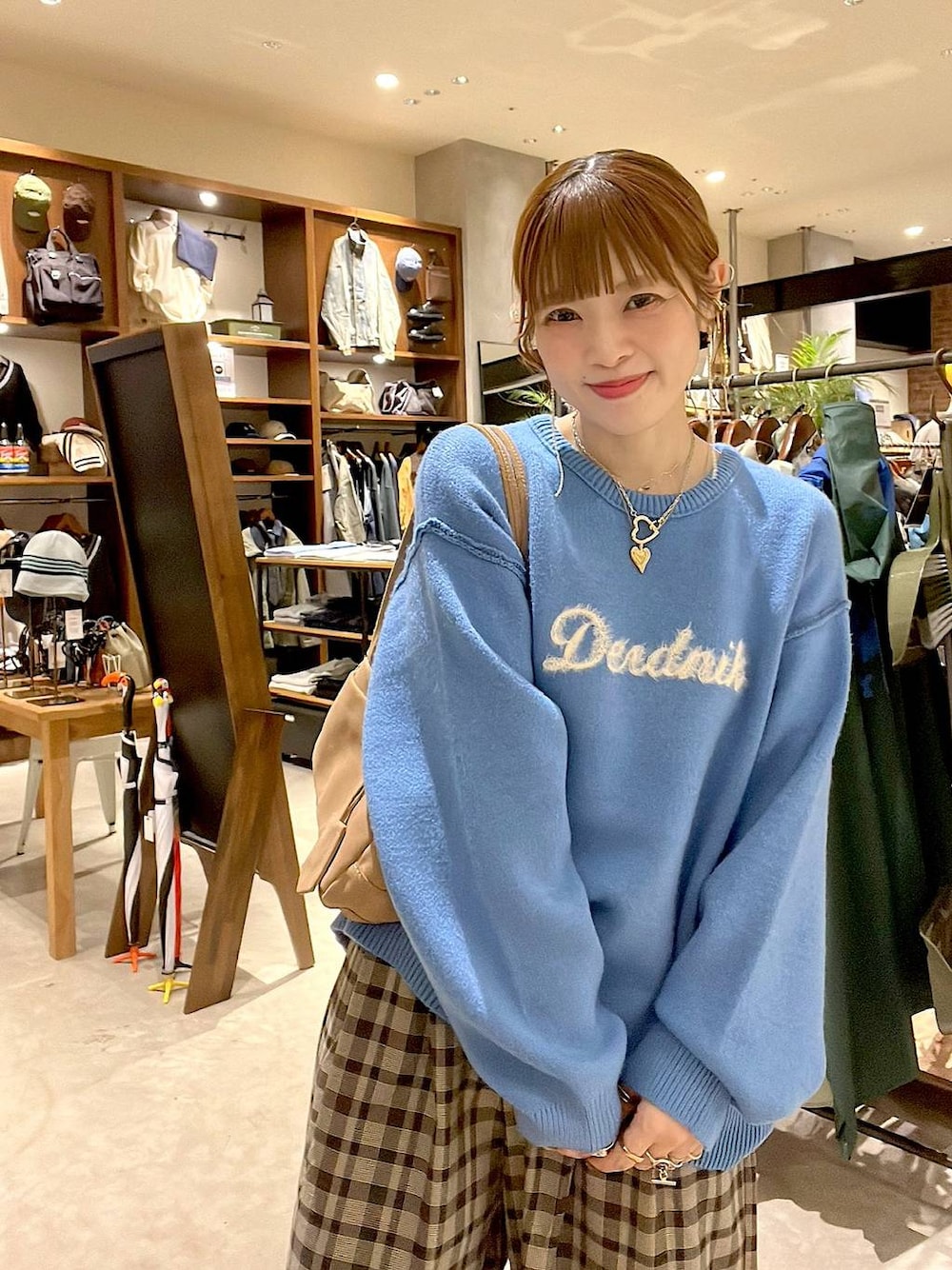 ブラウン系のその他パンツ、ブルー系のニット/セーター、ベージュ系のボストンバッグを着用したレディースの秋コーディネートの1枚目の写真