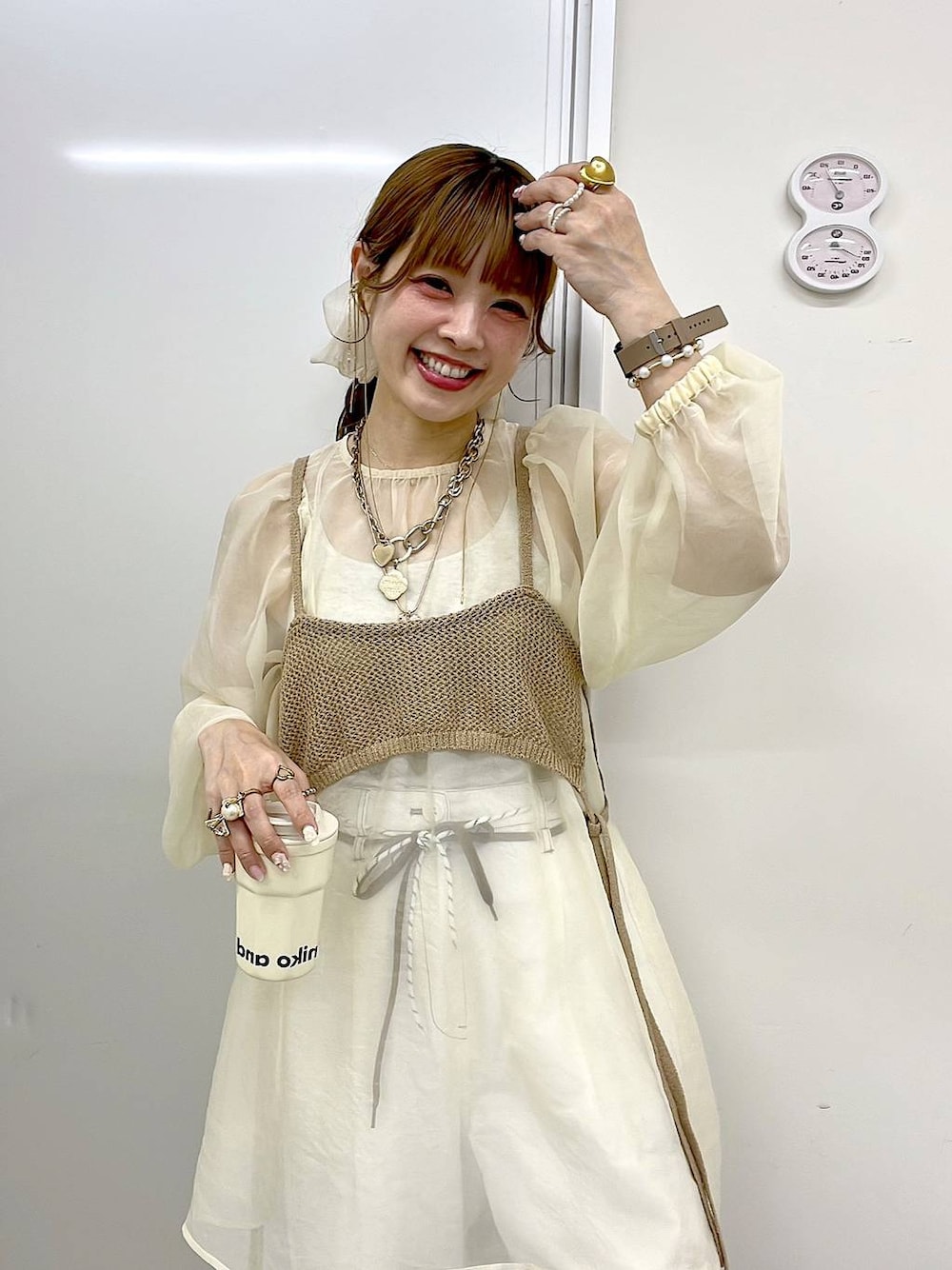 ベージュ系のスニーカー、ゴールド系のリング、グリーン系のアナログ腕時計を着用したレディースの春コーディネートの1枚目の写真