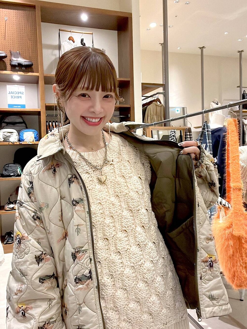 グリーン系のその他アウター、ベージュ系のニット/セーター、ゴールド系のネックレスを着用したレディースの秋コーディネートの1枚目の写真