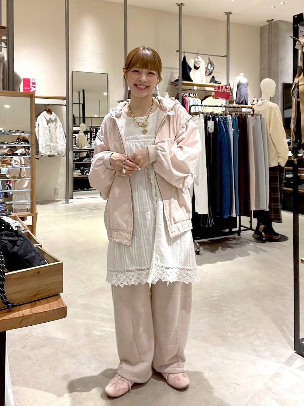 ピンク系のブルゾン、ホワイト系のスカート、ベージュ系のスウェットパンツを着用したレディースの冬コーディネートの1枚目の写真