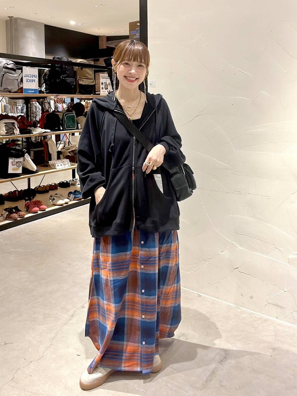 ブラック系のショルダーバッグ、イエロー系のネックレスを着用したレディースの秋コーディネートの1枚目の写真