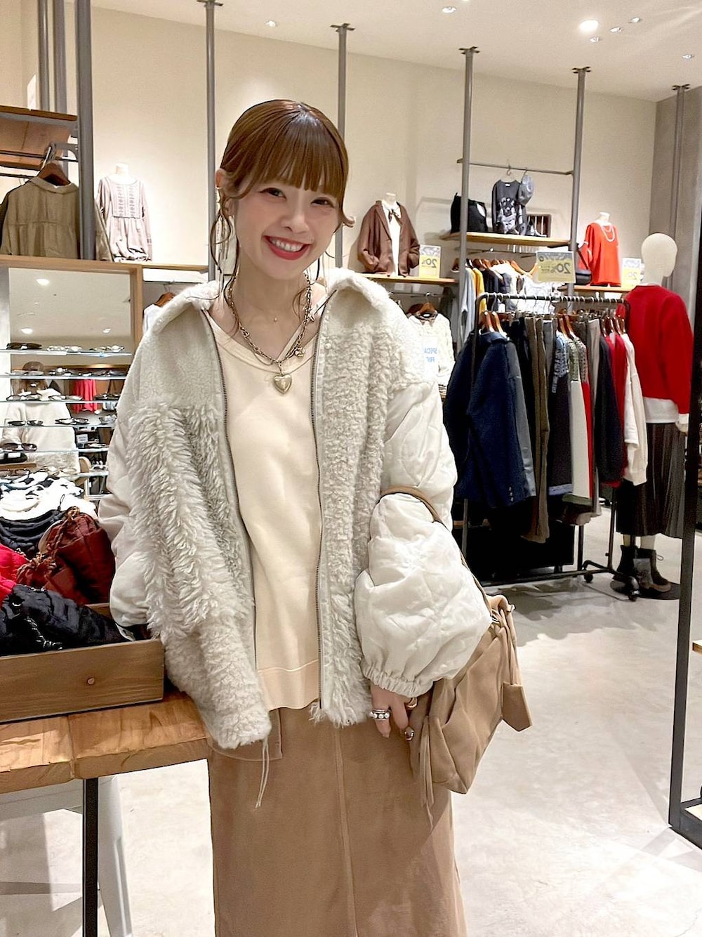 ベージュ系のブルゾン、イエロー系のスカート、ベージュ系のボストンバッグを着用したレディースの秋コーディネートの1枚目の写真