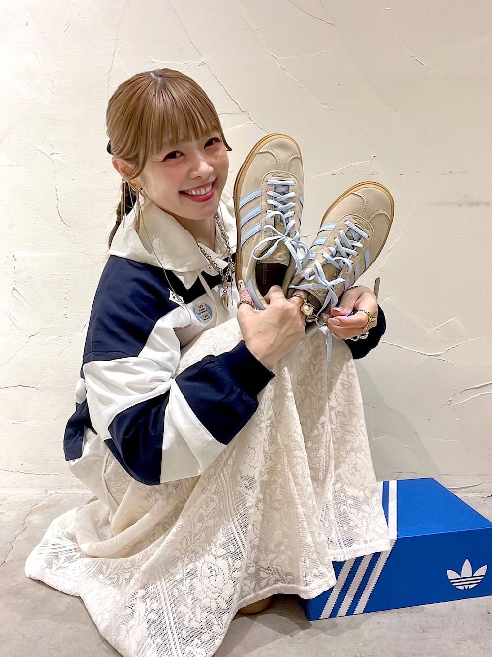 ベージュ系のスニーカー、ホワイト系のシャツ/ブラウス、ブルー系のTシャツ/カットソーを着用したレディースの春コーディネートの1枚目の写真