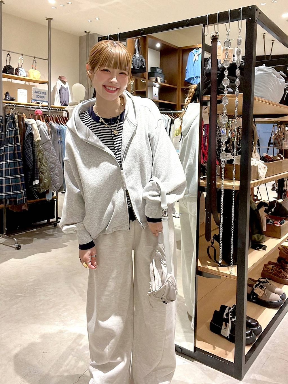 グレー系のスウェットパンツ、グレー系のパーカー、ブルー系のカーディガン/ボレロを着用したレディースの冬コーディネートの1枚目の写真