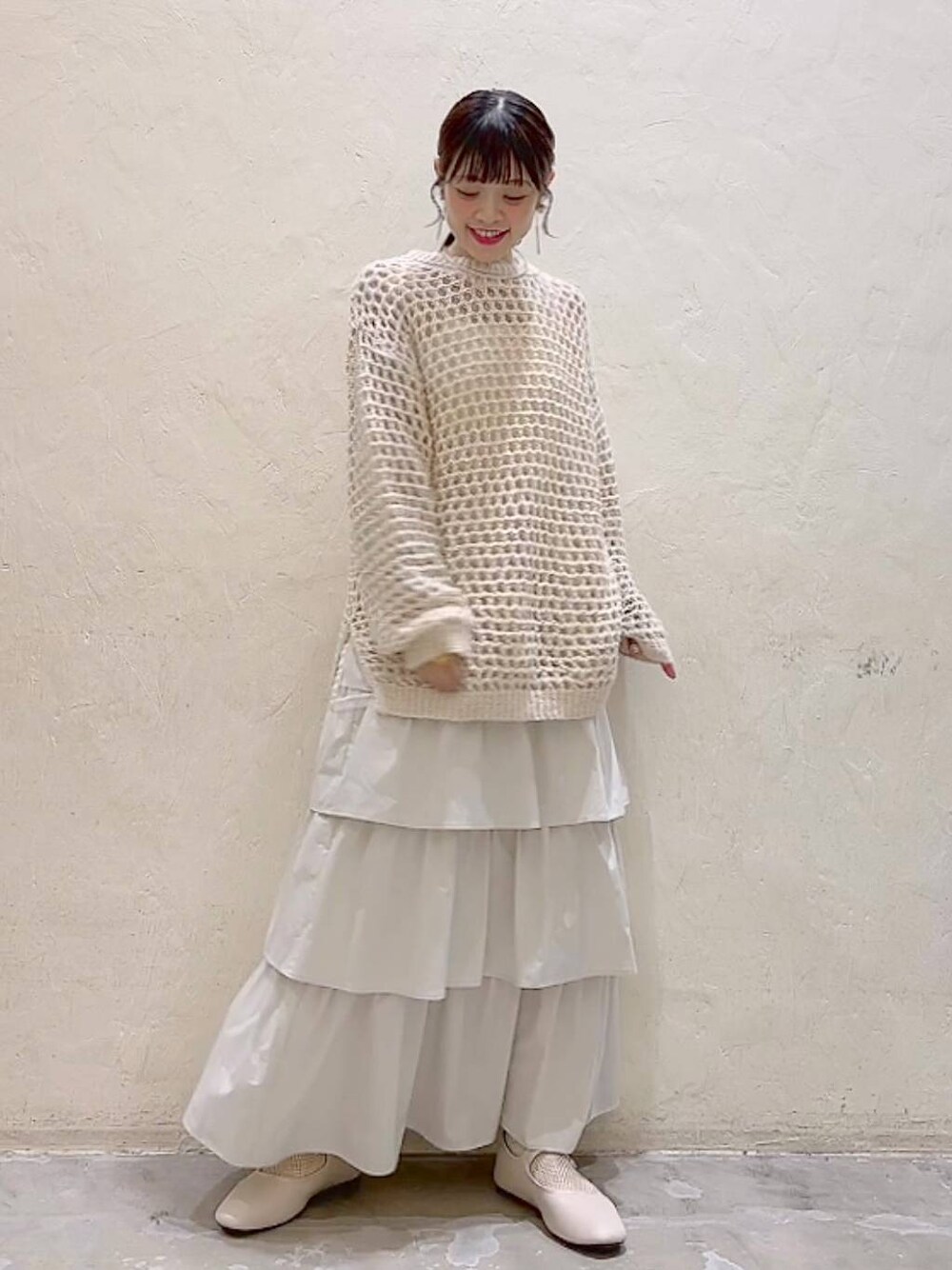 ホワイト系のパンプス、ベージュ系のニット/セーター、ベージュ系のスカートを着用したレディースの冬コーディネートの1枚目の写真