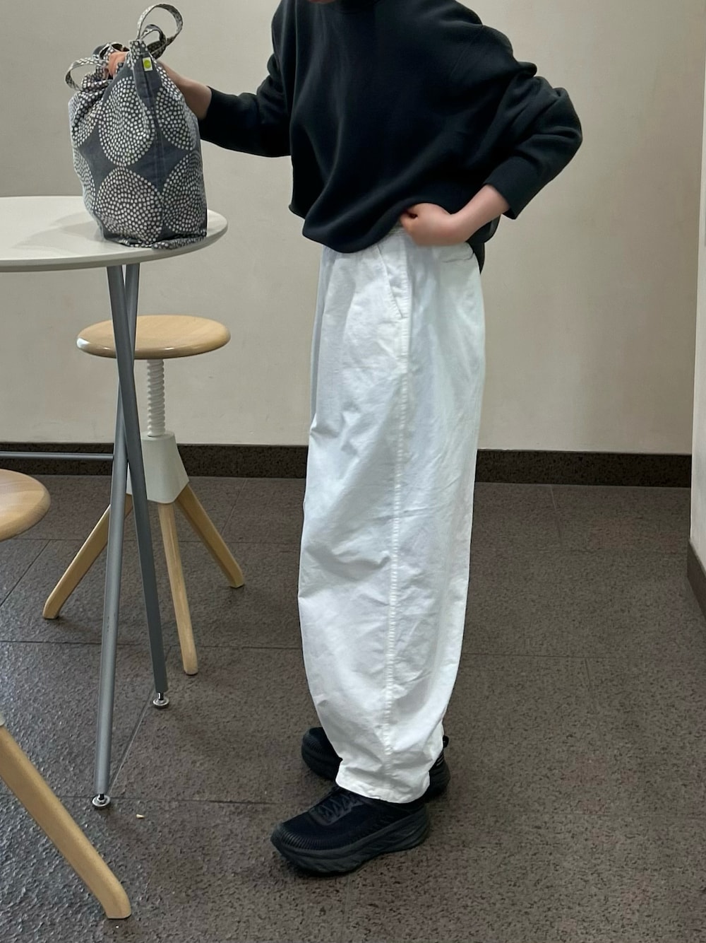 ホワイト系のチノパンツ、ブラック系のスニーカー、グレー系のトップスを着用したレディースの夏コーディネートの1枚目の写真