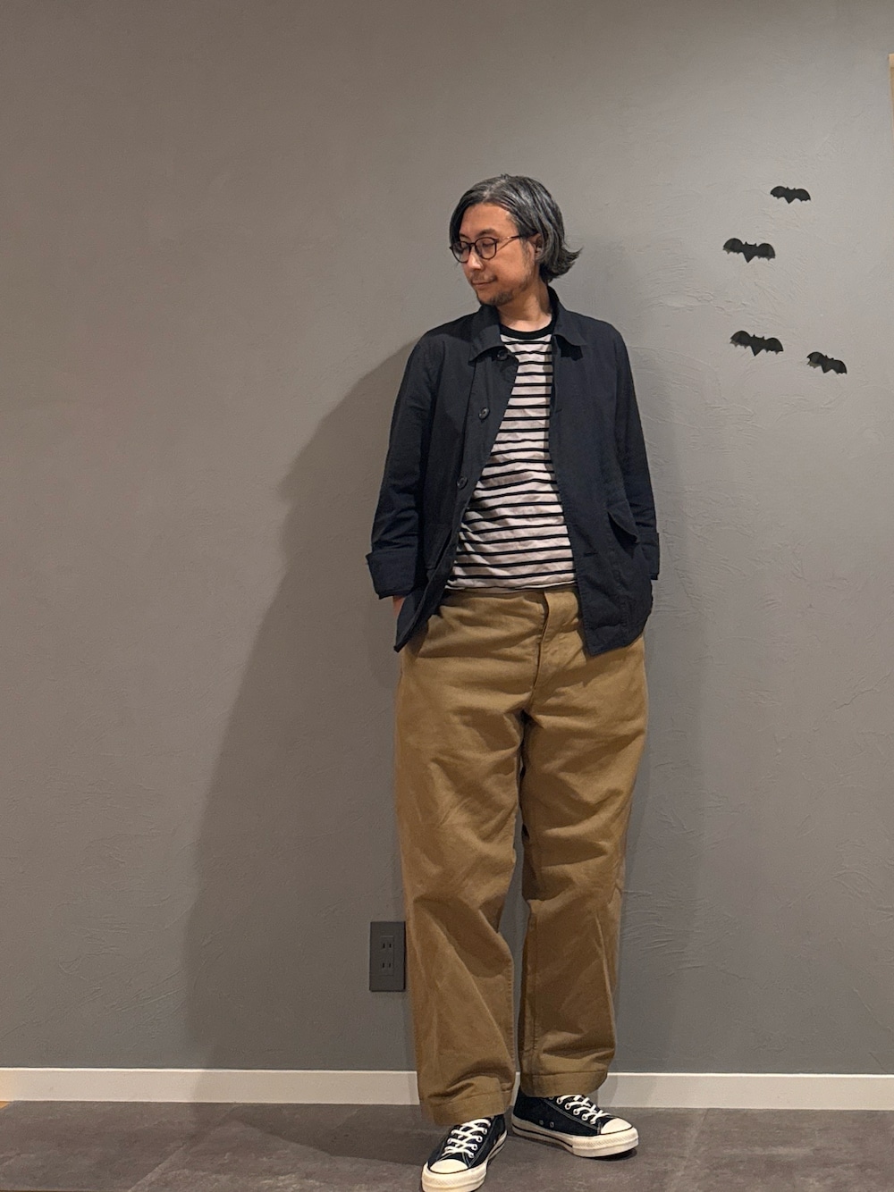 ブラック系のスニーカー、グレー系のTシャツ/カットソー、ブルー系のカバーオールを着用したメンズの秋コーディネートの1枚目の写真