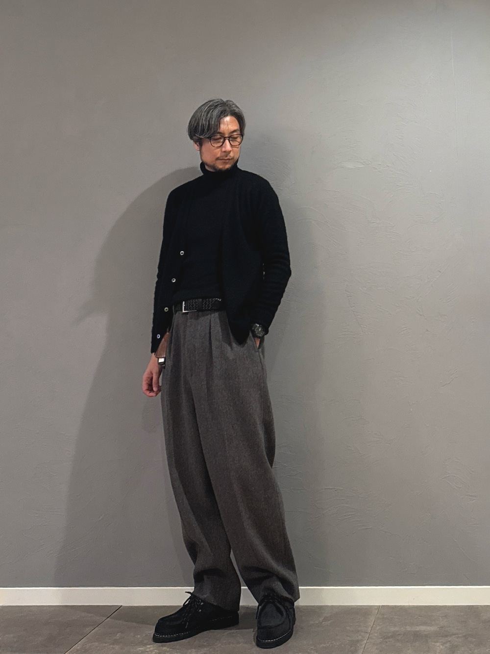 グレー系のスラックス、ブラック系のニット/セーター、グレー系のスラックスを着用したメンズの秋コーディネートの1枚目の写真
