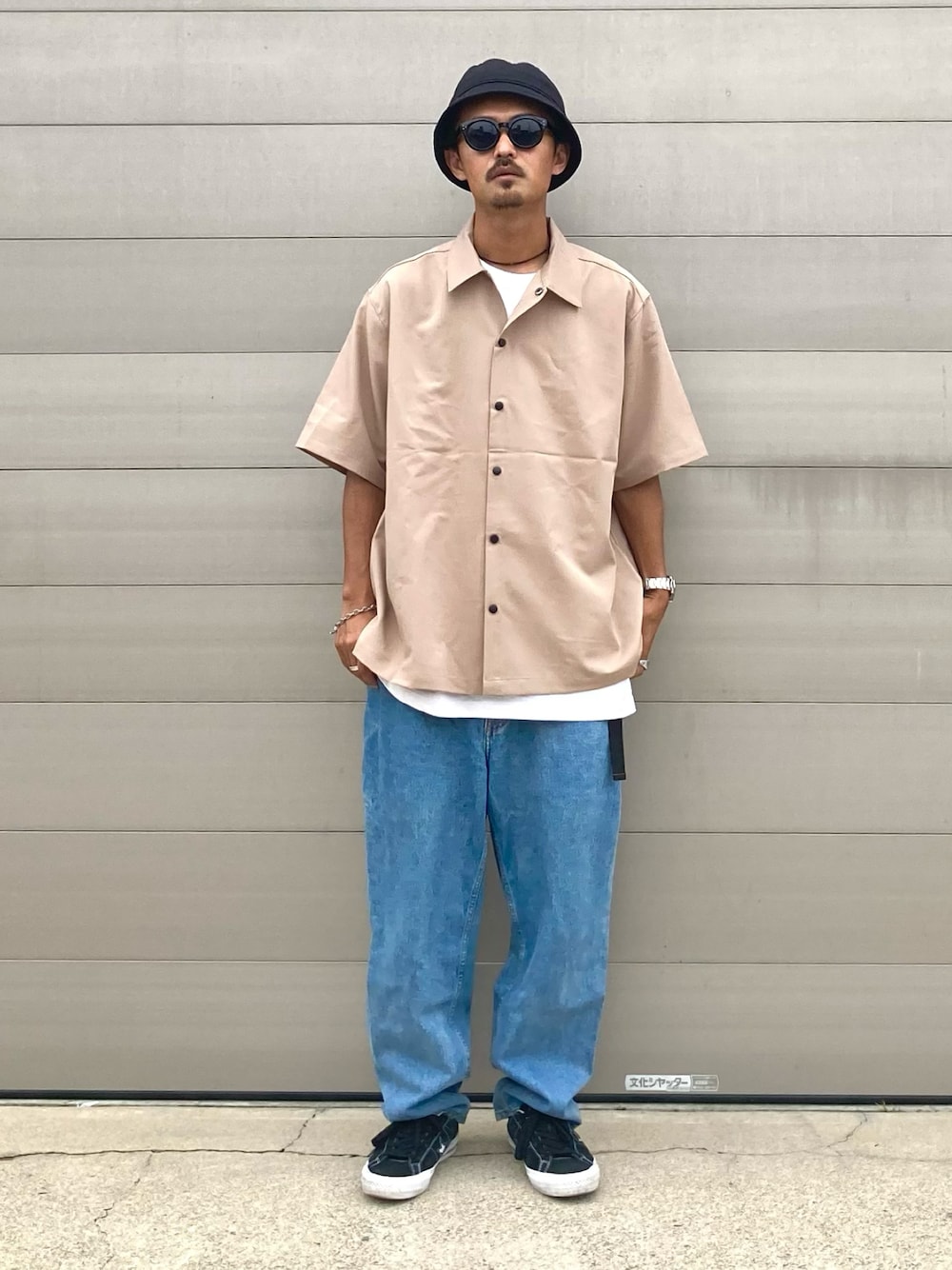 ベージュ系のシャツ/ブラウス、ブルー系のデニムパンツ、ブラック系のスニーカーを着用したメンズの夏コーディネートの1枚目の写真