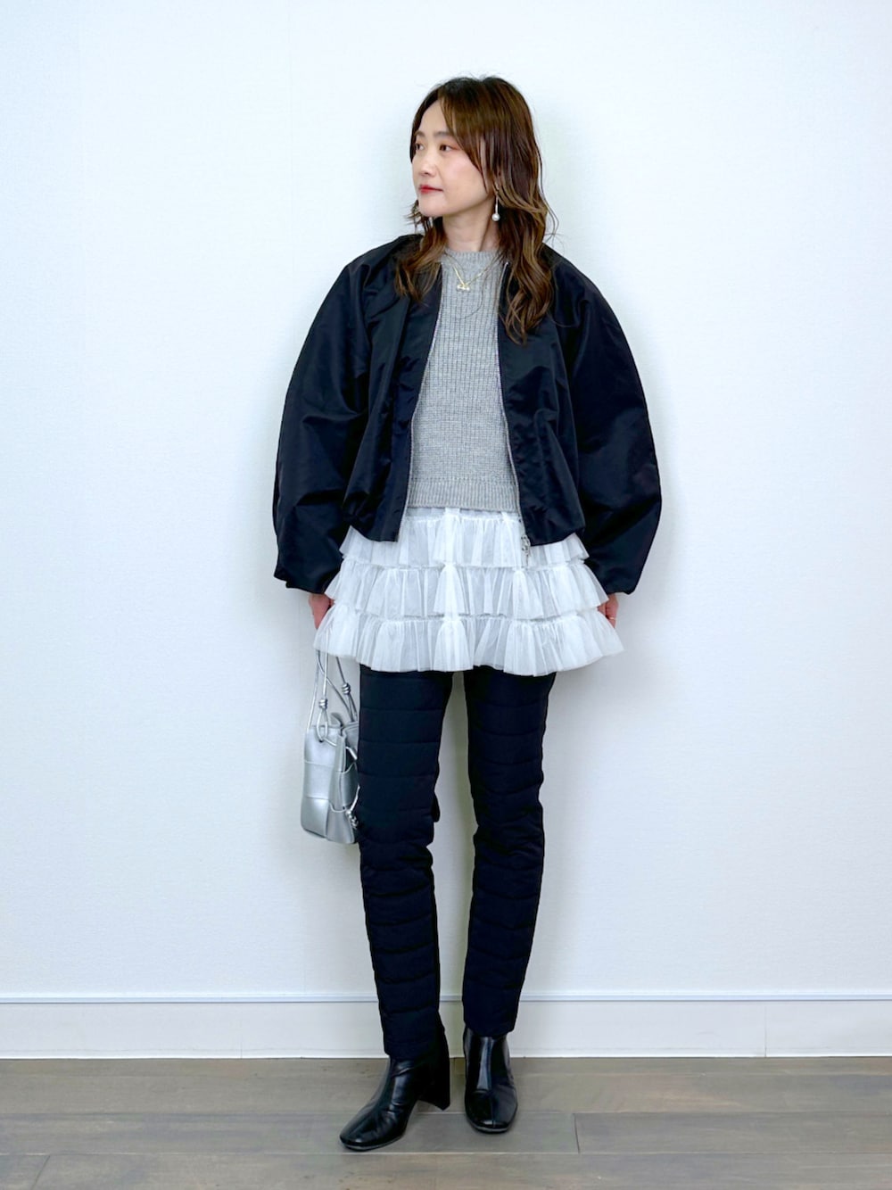 ブラック系のブルゾン、ベージュ系のニット/セーター、ブラック系のその他パンツを着用したレディースの冬コーディネートの1枚目の写真