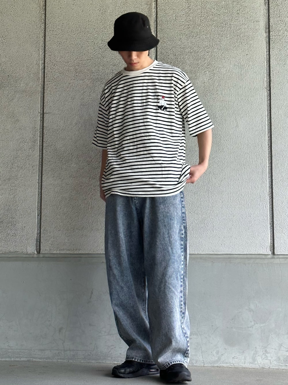 ホワイト系のTシャツ/カットソー、ブルー系のデニムパンツ、ブラック系のスニーカーを着用したメンズの春コーディネートの1枚目の写真
