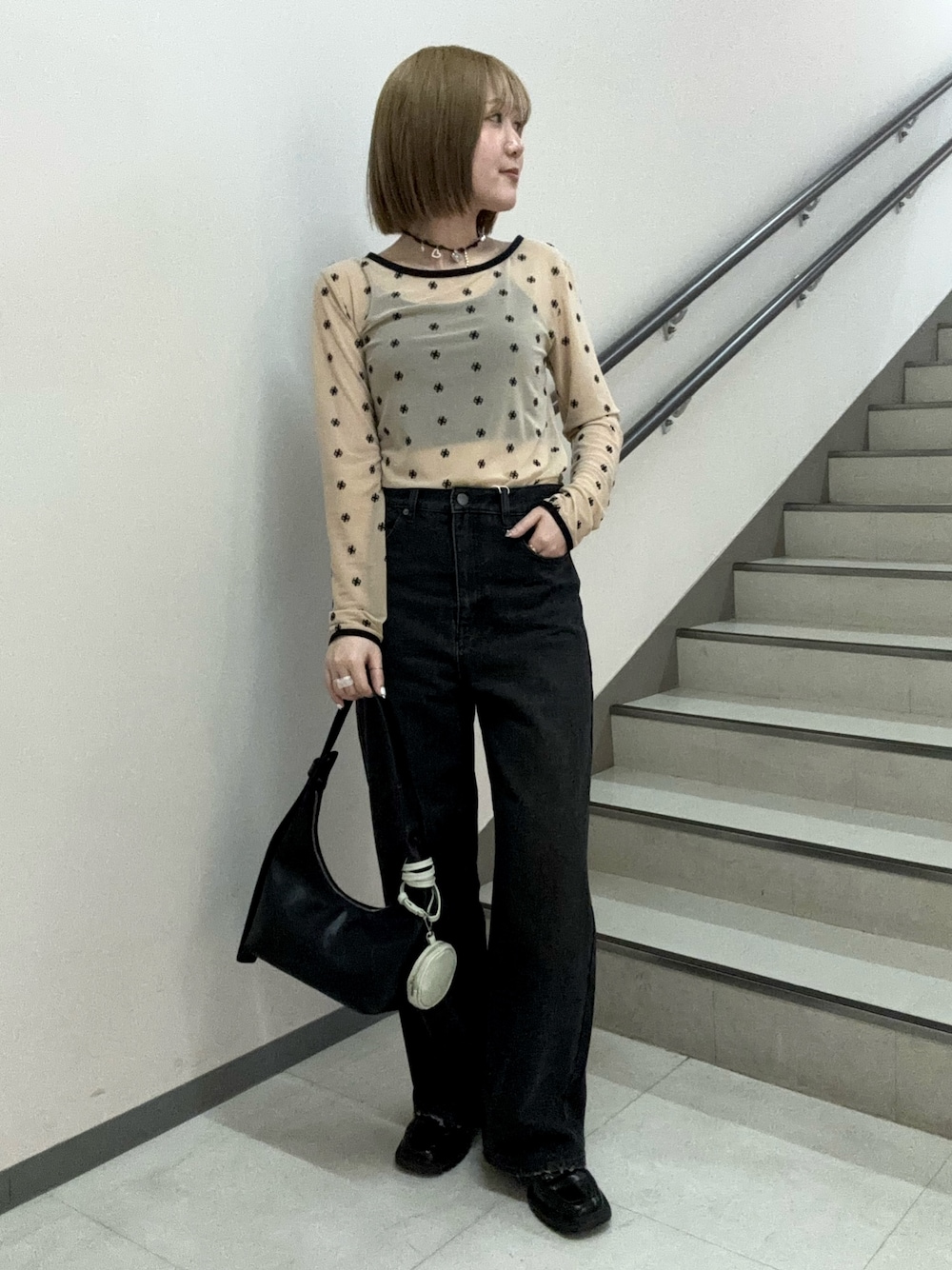 ベージュ系のTシャツ/カットソー、ブラック系のキャミソール、ブラック系のハンドバッグを着用したレディースの春コーディネートの1枚目の写真