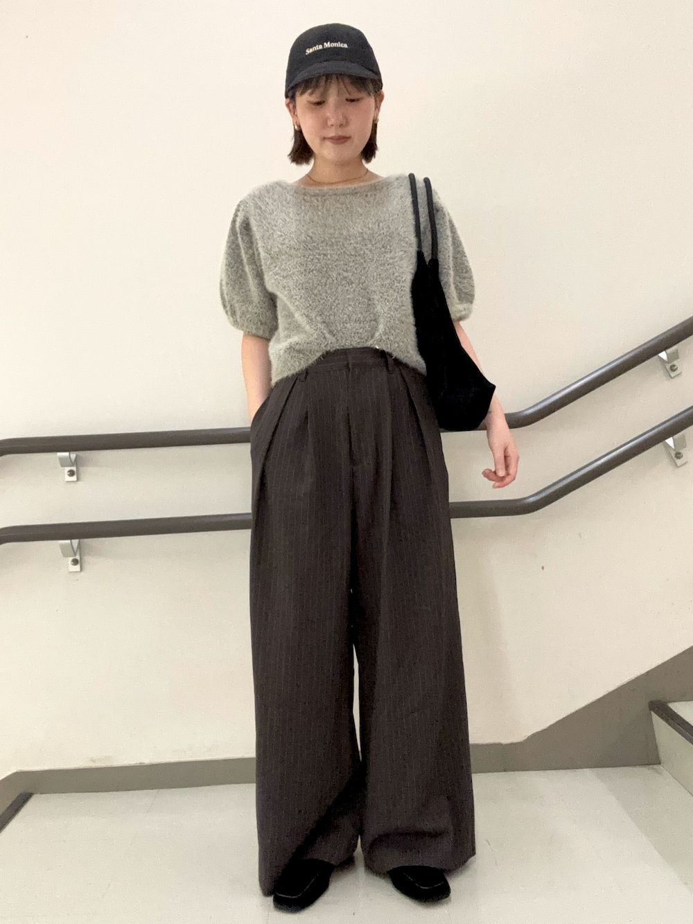 ブラウン系のその他パンツ、ブラック系のトートバッグ、グレー系のニット/セーターを着用したレディースの夏コーディネートの1枚目の写真