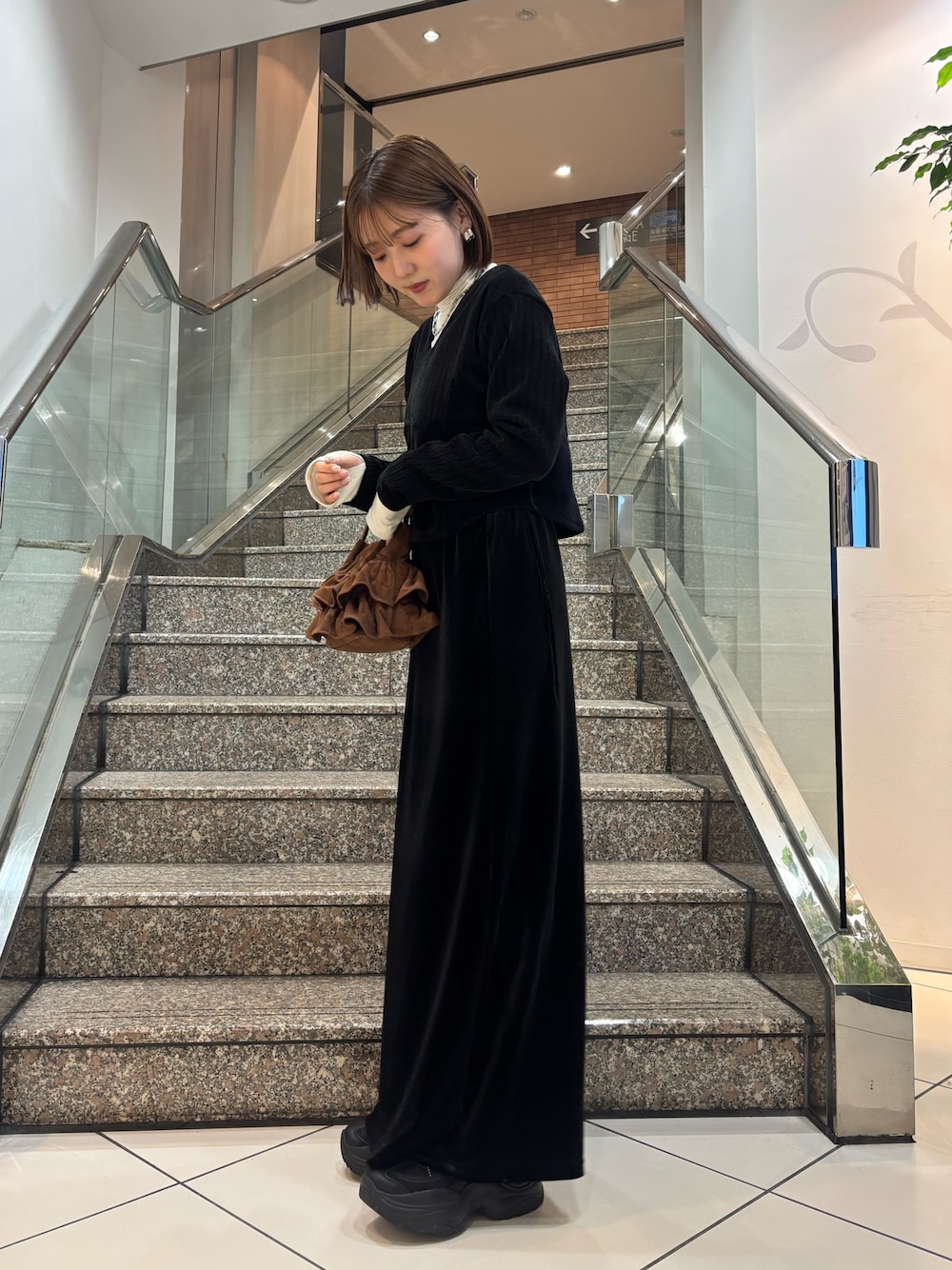 ホワイト系のTシャツ/カットソー、ブラック系のカーディガン/ボレロ、ブラック系のスカートを着用したレディースの冬コーディネートの1枚目の写真