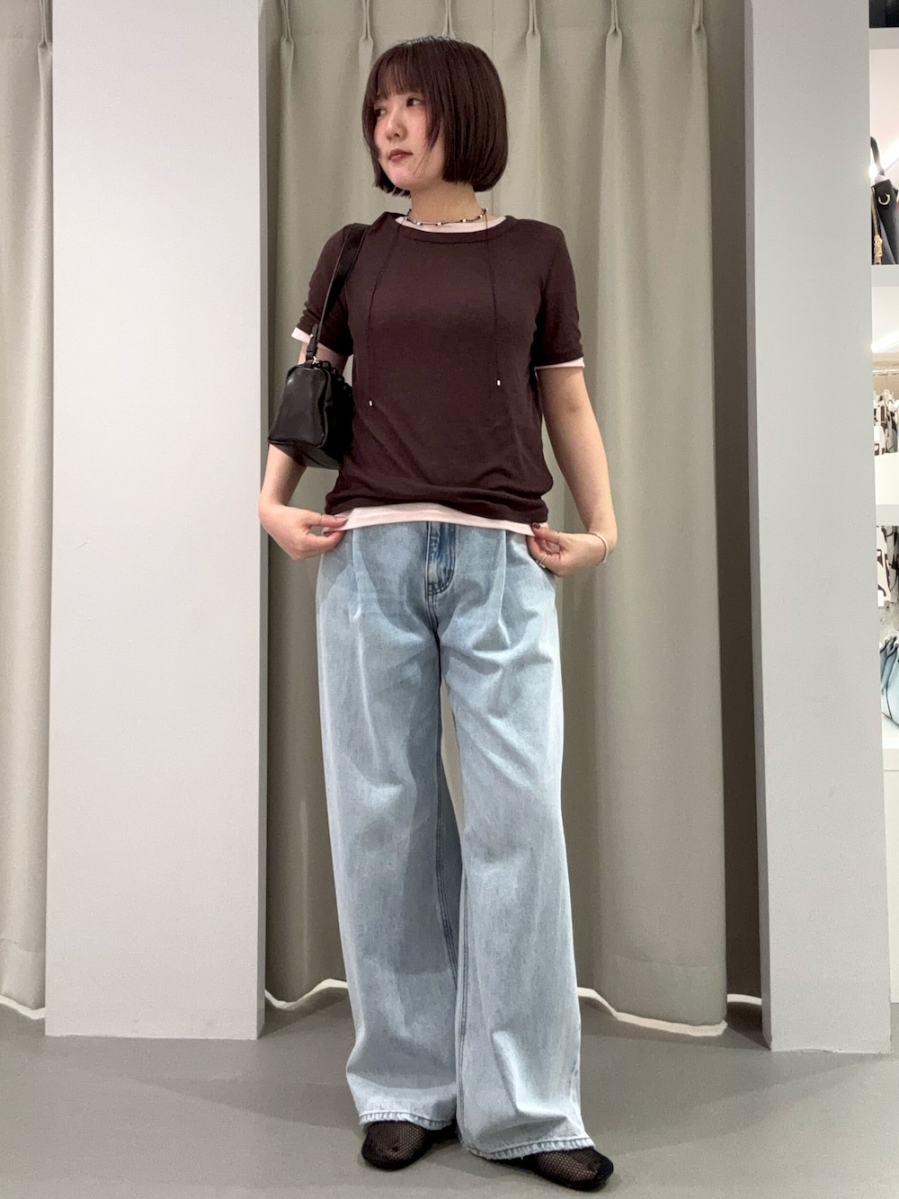 ブルー系のデニムパンツ、ブラウン系のショルダーバッグ、ブラック系のパンプスを着用したレディースの夏コーディネートの1枚目の写真