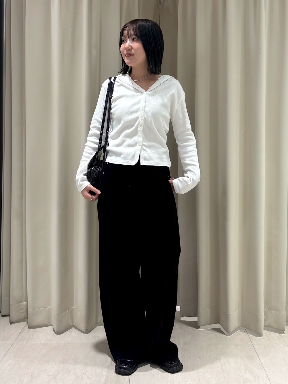 ホワイト系のパーカー、ブラック系のその他パンツ、ブラック系のショルダーバッグを着用したレディースの秋コーディネートの1枚目の写真