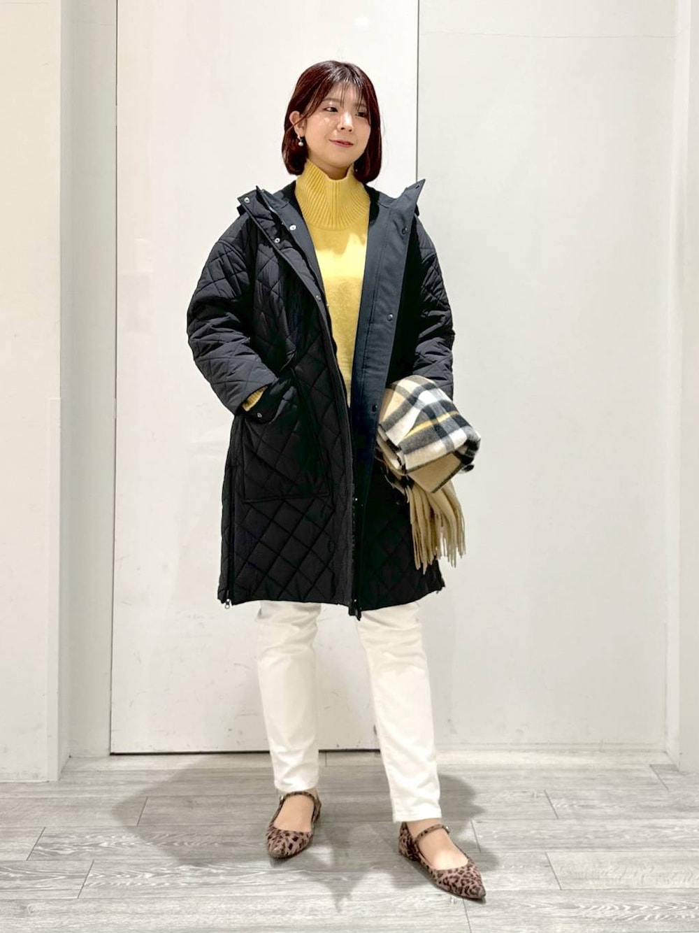 イエロー系のニット/セーター、ホワイト系のその他パンツ、ブラック系のダウンジャケット/コートを着用したレディースの冬コーディネートの1枚目の写真