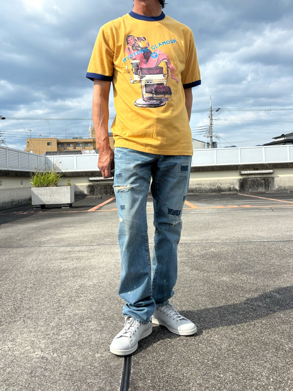 イエロー系のTシャツ/カットソー、ブルー系のデニムパンツ、グレー系のスニーカーを着用したメンズの夏コーディネートの1枚目の写真