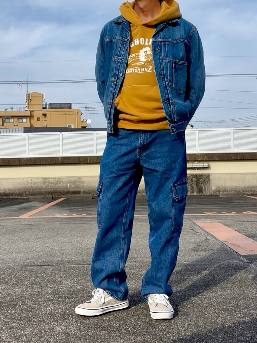 イエロー系のTシャツ/カットソー、ブルー系のデニムパンツ、ブルー系のデニムジャケットを着用したメンズの冬コーディネートの1枚目の写真