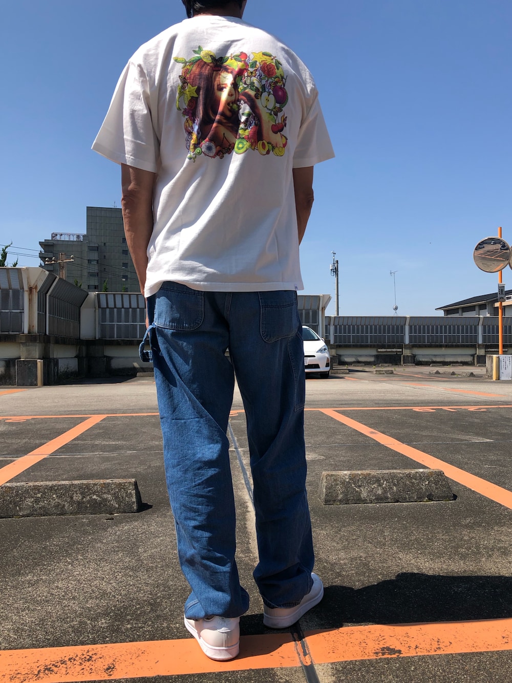 ホワイト系のTシャツ/カットソー、ブルー系のチノパンツ、グレー系のスニーカーを着用したメンズの夏コーディネートの1枚目の写真