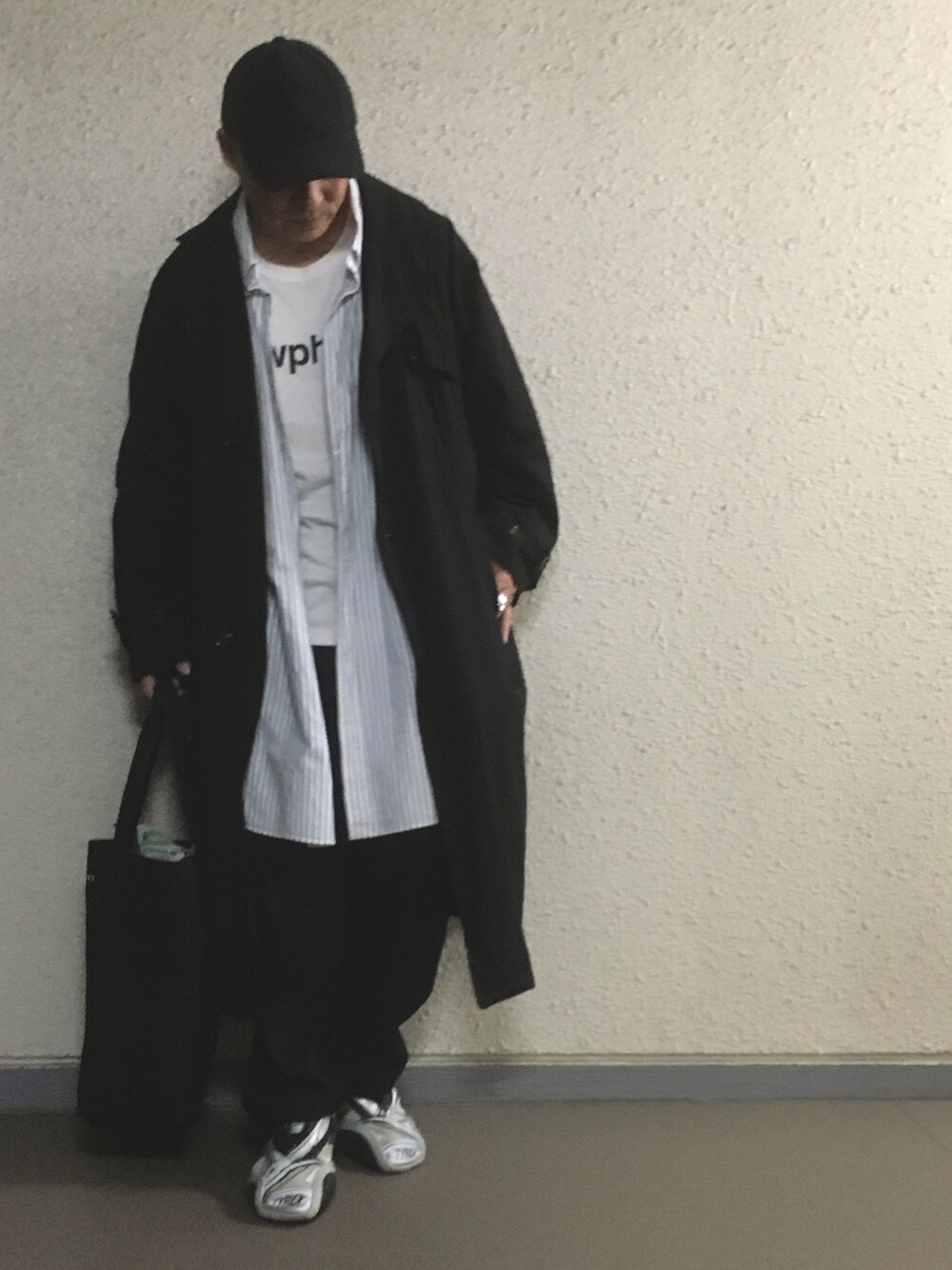 ホワイト系のTシャツ/カットソー、ブルー系のシャツ/ブラウス、ブラック系のトレンチコートを着用したメンズの春コーディネートの1枚目の写真