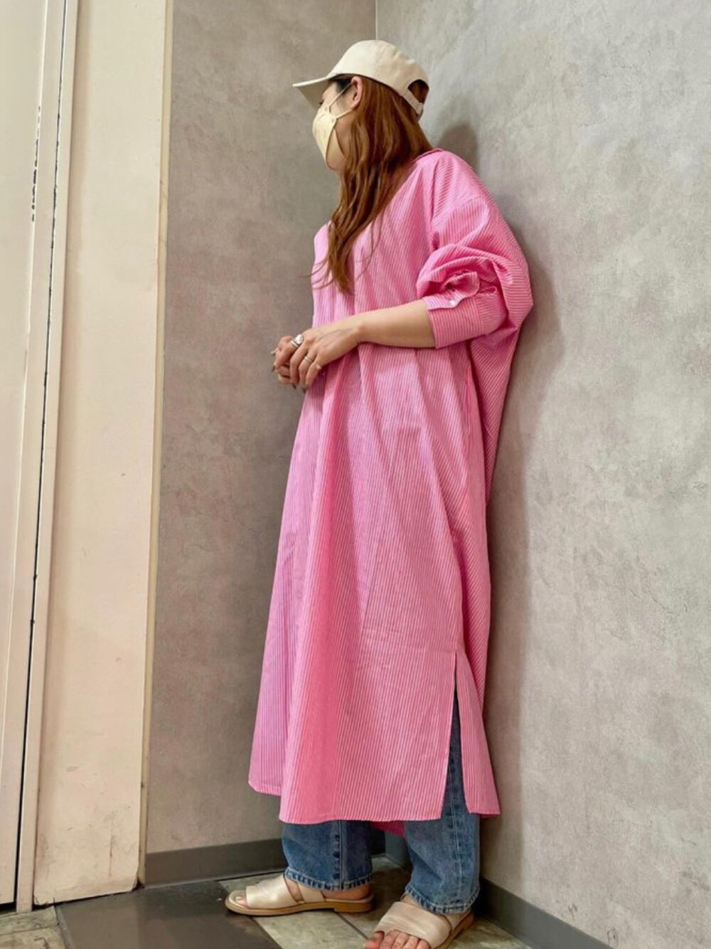 ピンク系のワンピース、ブルー系のデニムパンツを着用したレディースの夏コーディネートの1枚目の写真