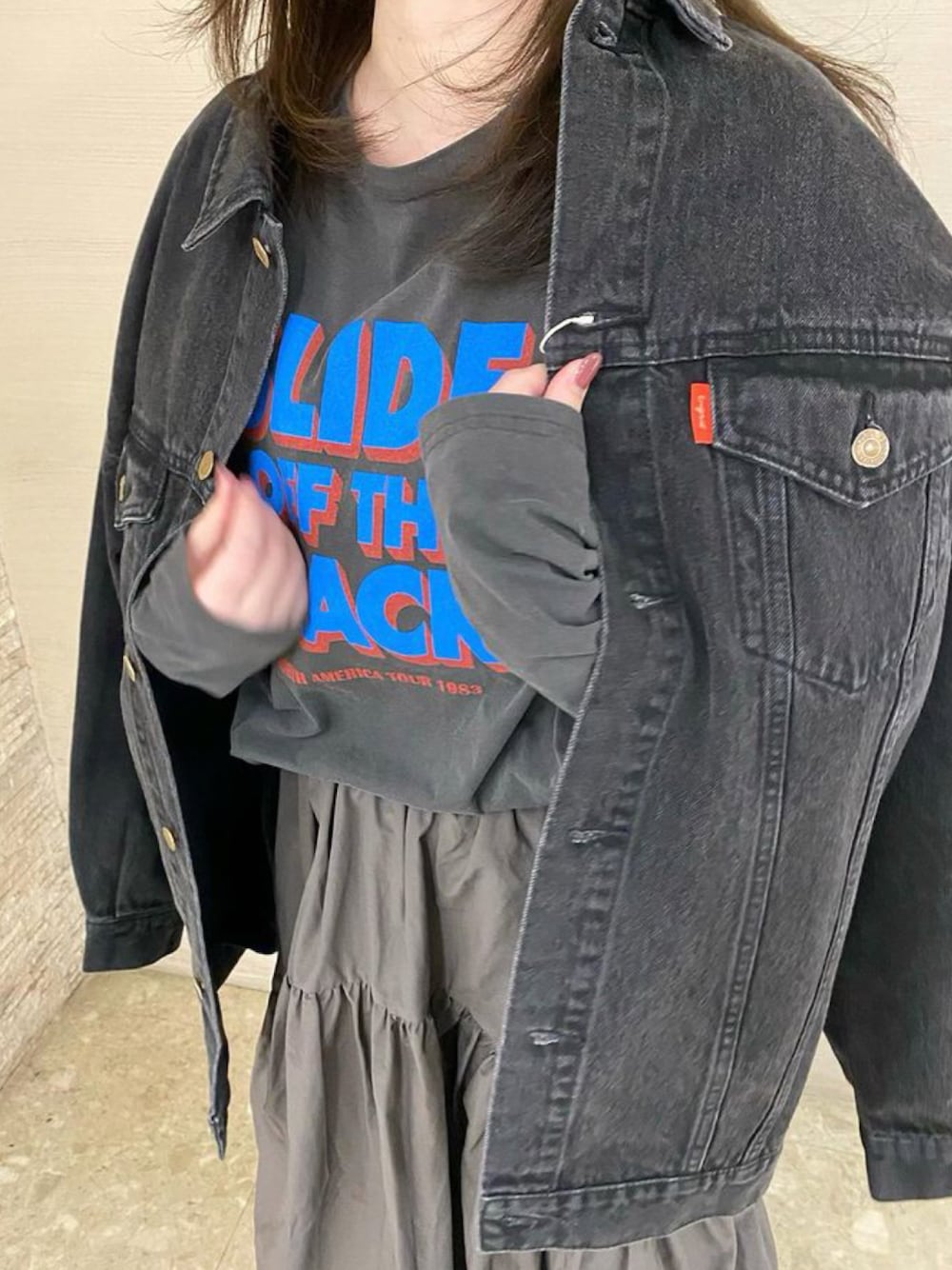 ブラック系のデニムジャケット、グレー系のTシャツ/カットソー、グレー系のスカートを着用したレディースの冬コーディネートの1枚目の写真