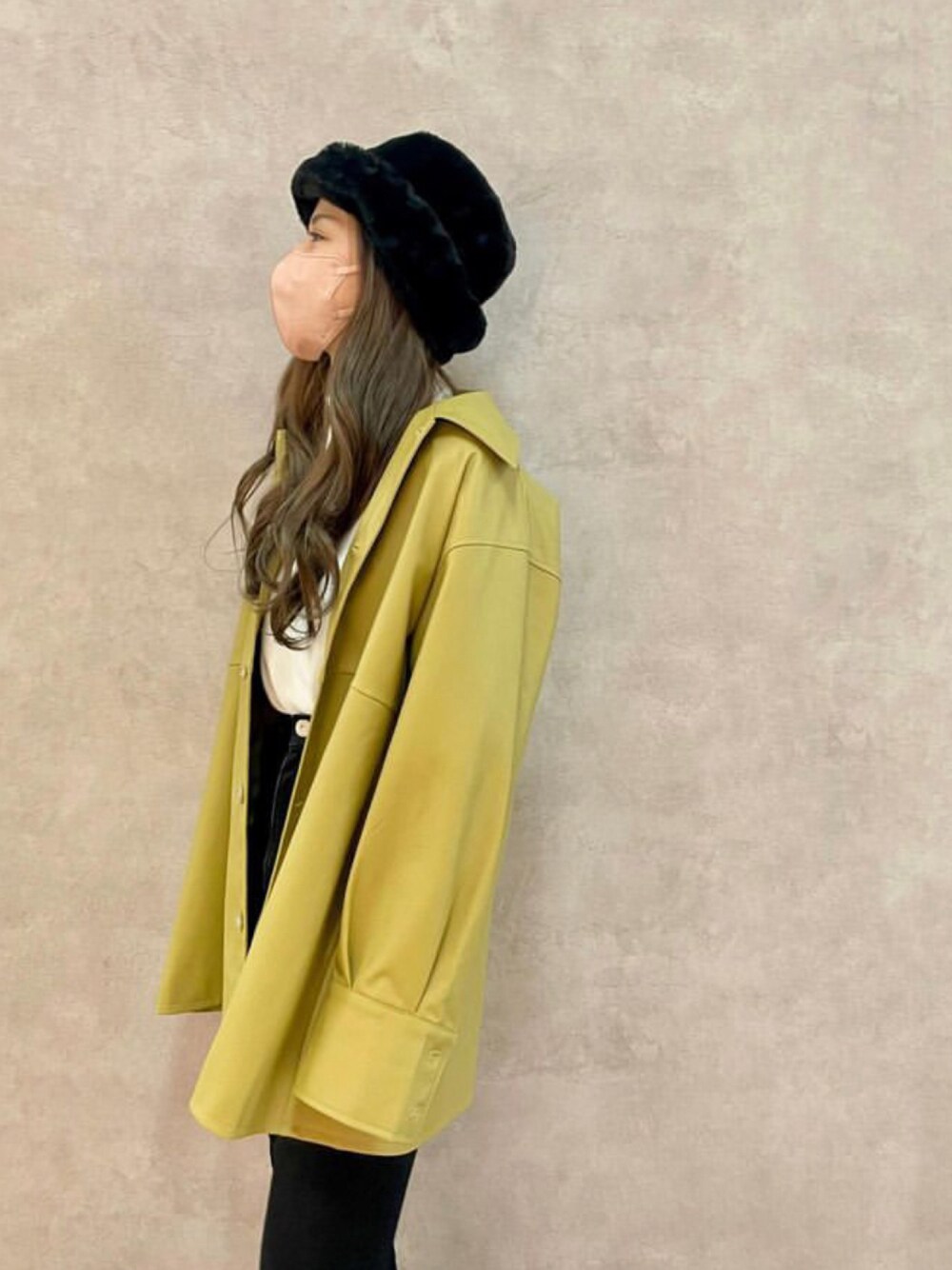 イエロー系のブルゾン、ブラック系のハットを着用したレディースの秋コーディネートの1枚目の写真