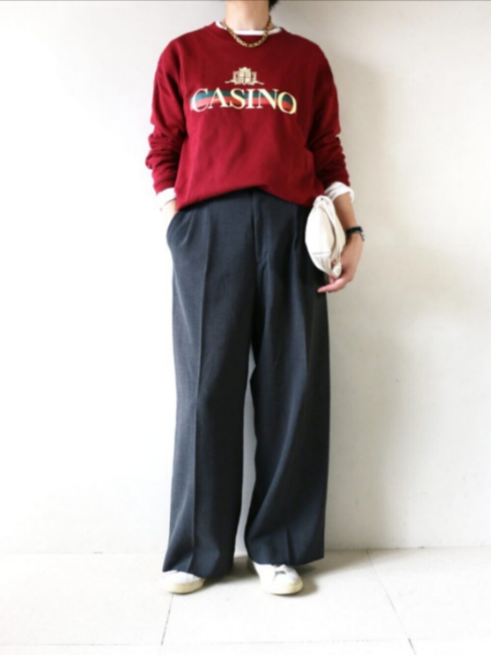 レッド系のスウェット、グレー系のスラックスを着用したレディースの秋コーディネートの1枚目の写真