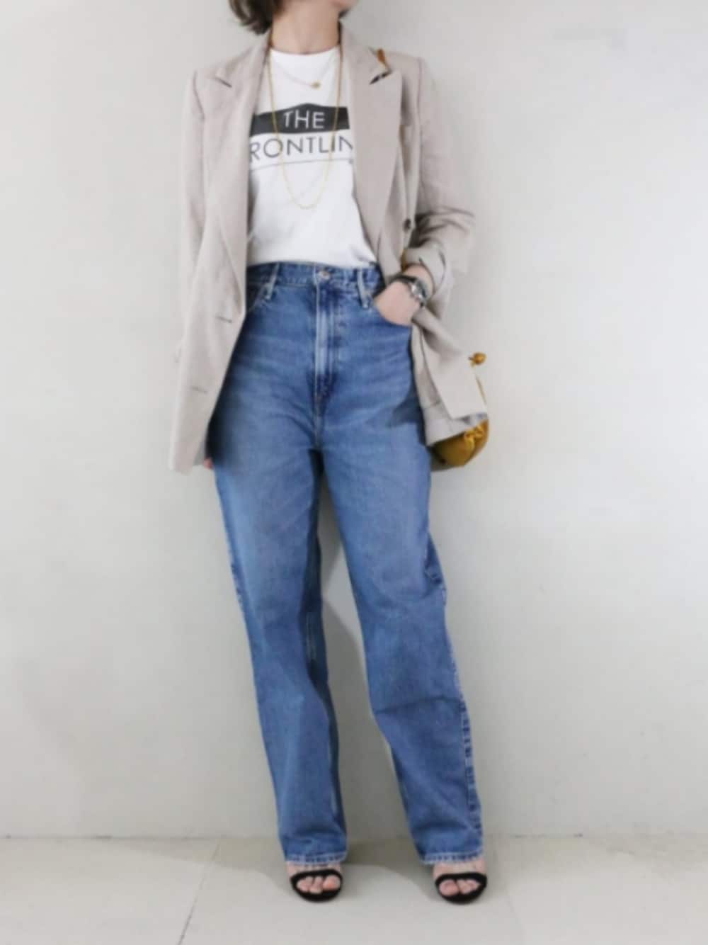 ベージュ系のテーラードジャケット、ブルー系のデニムパンツ、ホワイト系のTシャツ/カットソーを着用したレディースの春コーディネートの1枚目の写真
