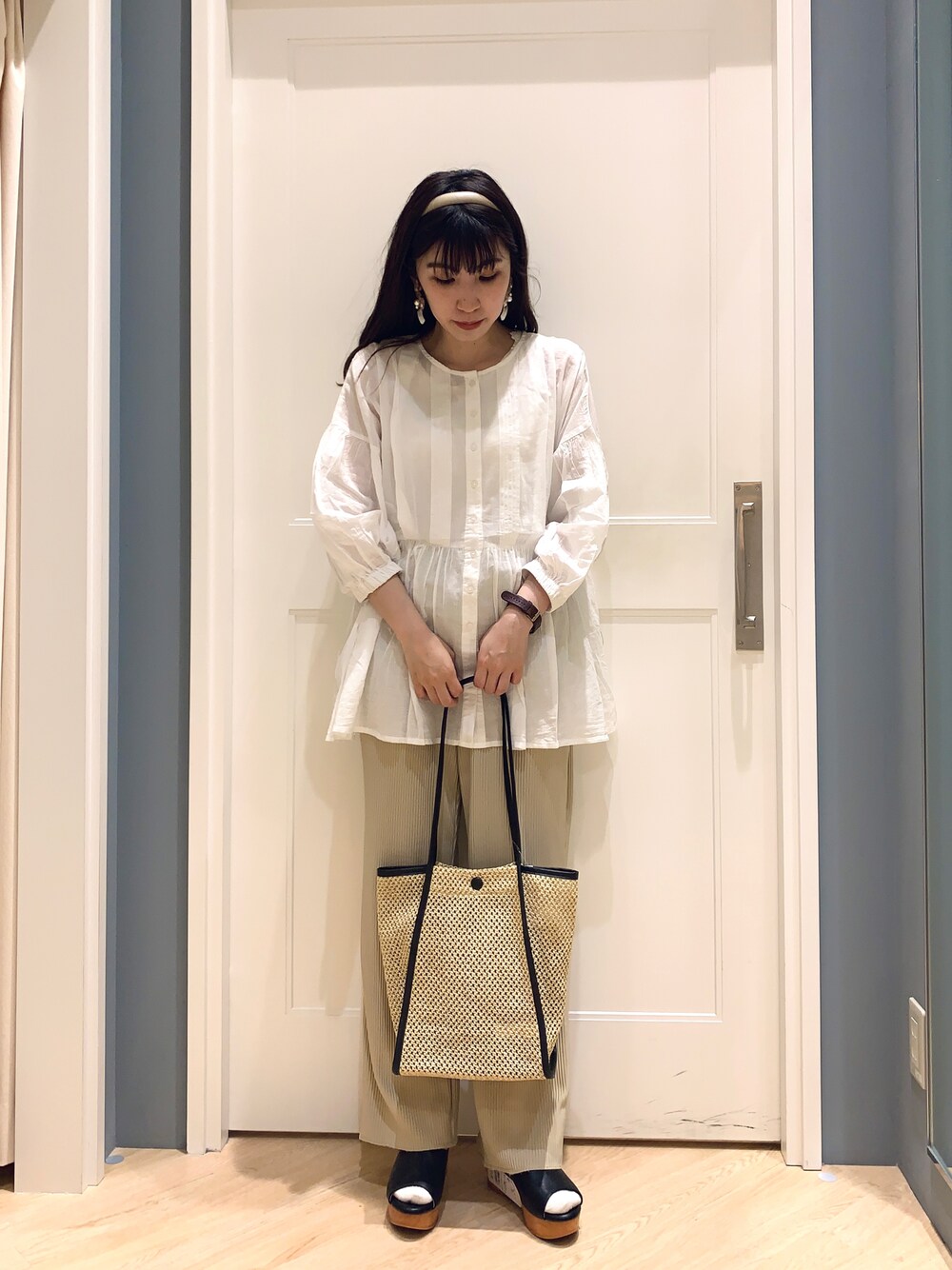 ホワイト系のシャツ/ブラウス、ベージュ系のその他パンツ、ブラック系のハンドバッグを着用したレディースの夏コーディネートの1枚目の写真