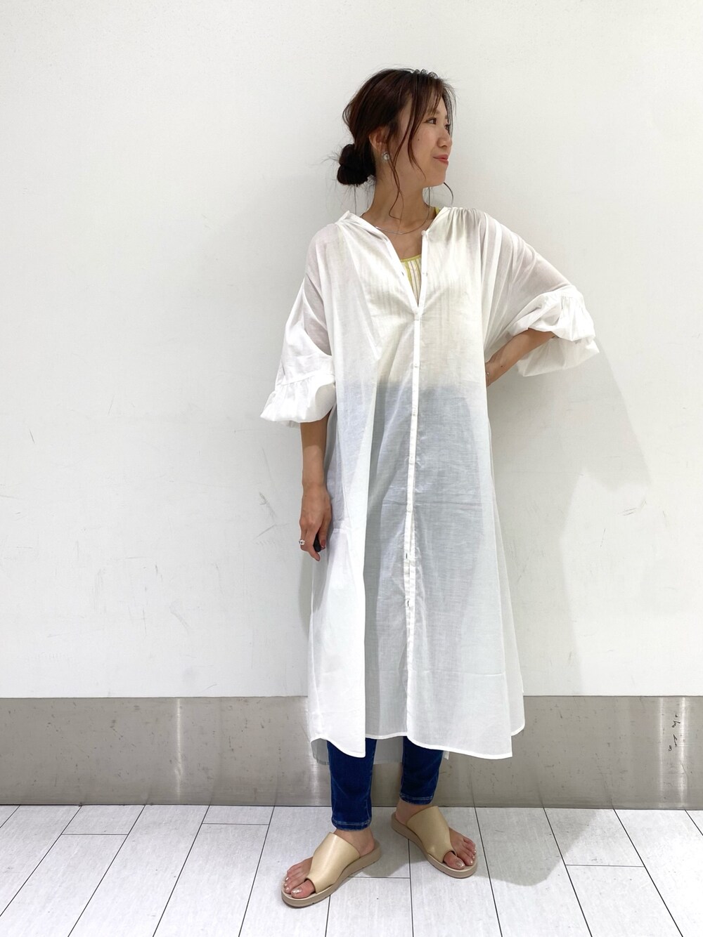 ホワイト系のワンピース、イエロー系のタンクトップ、ブルー系のデニムパンツを着用したレディースの夏コーディネートの1枚目の写真