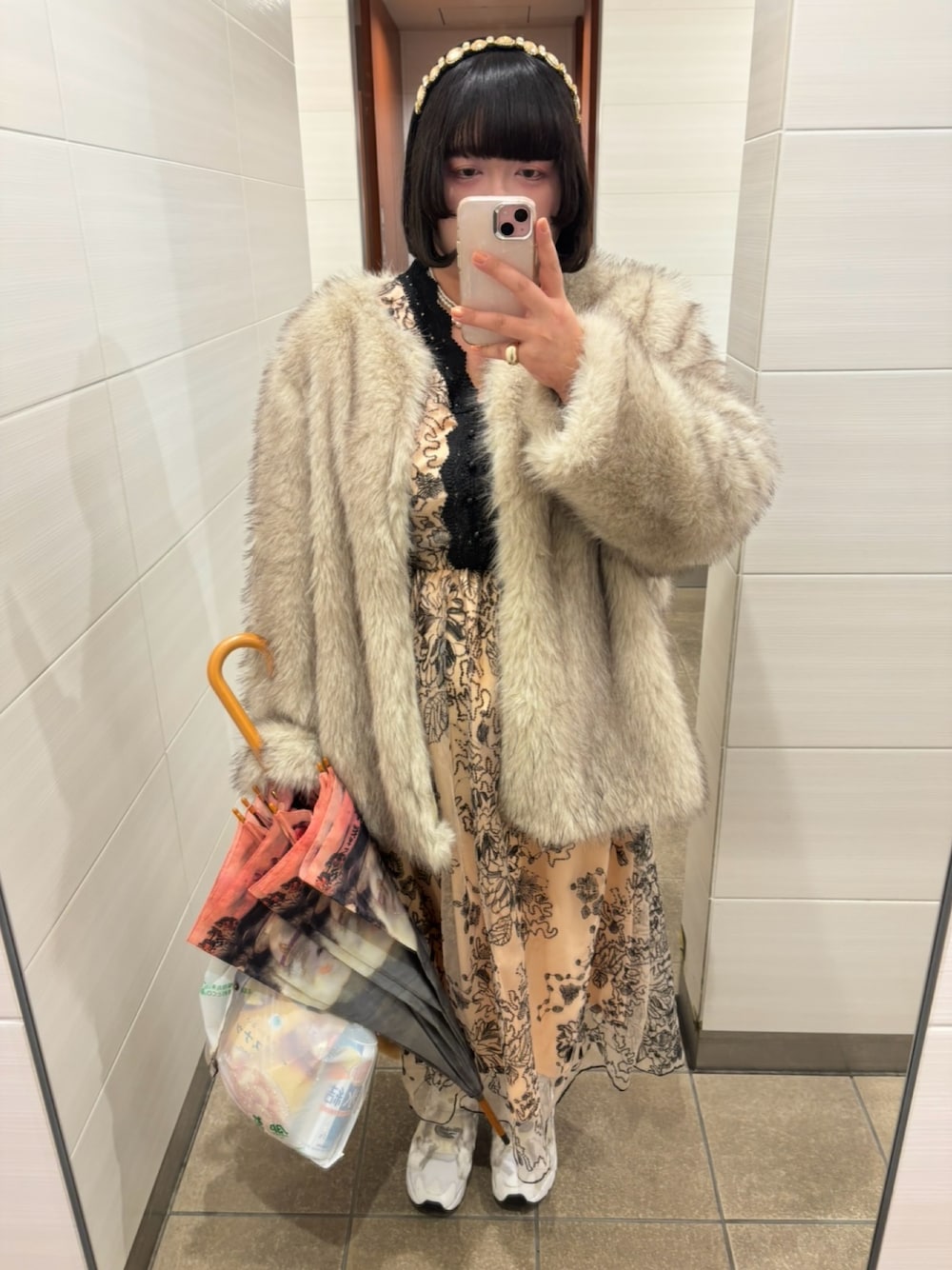 ホワイト系のスニーカーを着用したレディースの秋コーディネートの1枚目の写真