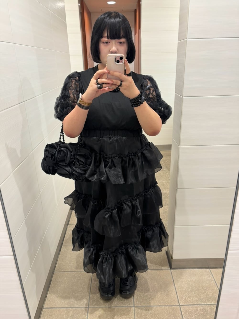 ブラック系のスカートを着用したレディースの秋コーディネートの1枚目の写真