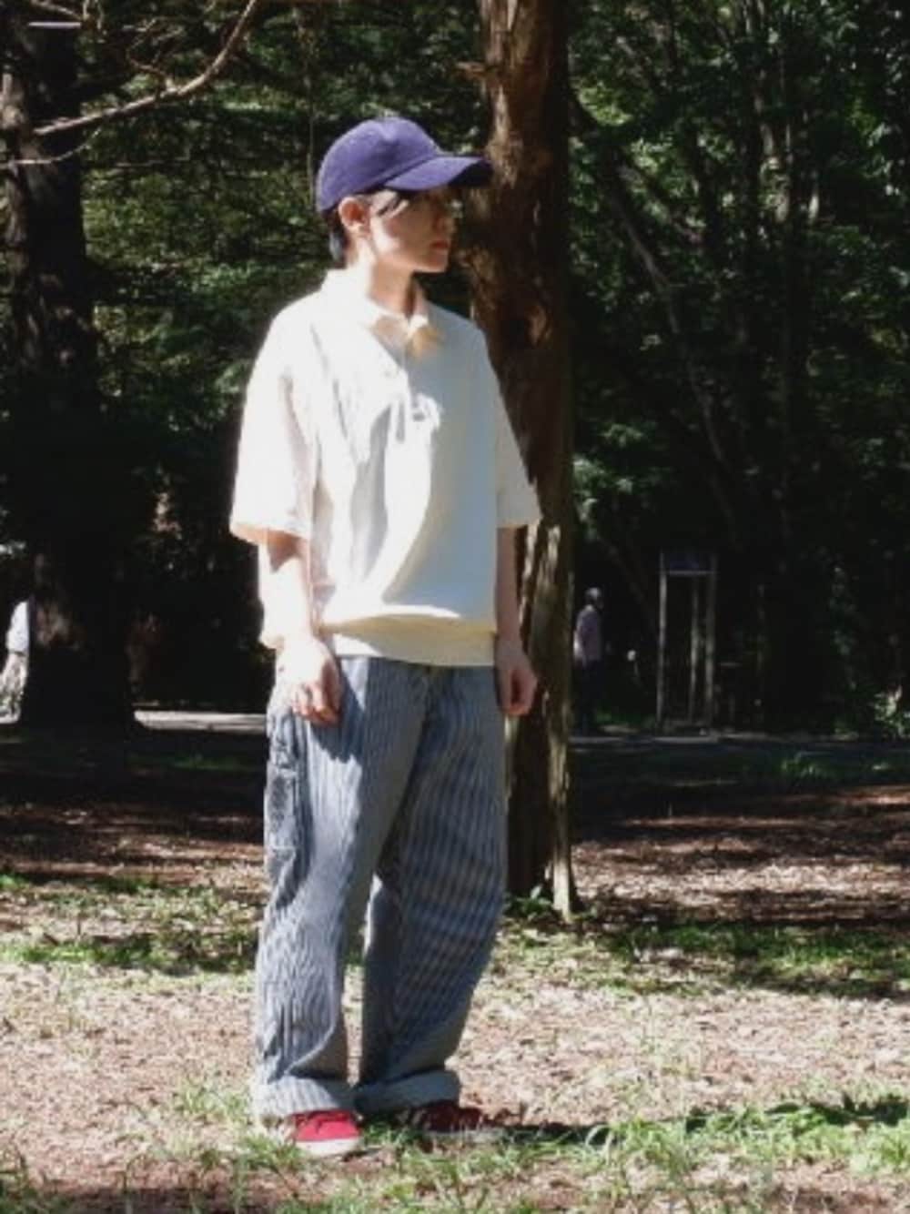 ブルー系のデニムパンツ、ホワイト系のポロシャツ、レッド系のスニーカーを着用したメンズの秋コーディネートの1枚目の写真